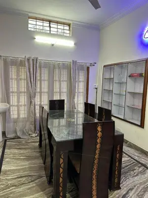 a dining room with a glass table and chairs at Raaha Luxury Home Stay in Mysore