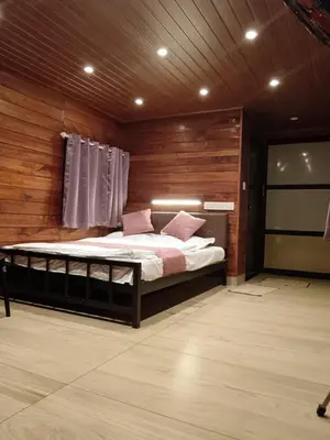 a bedroom with a bed in a room with wooden walls at Rain view wayanad in Wayanad