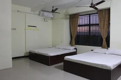 two beds in a room with a window at Aishvarya Residency in Coimbatore