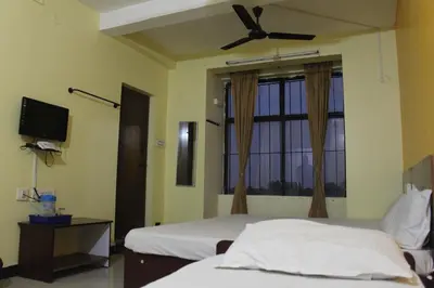 a bedroom with two beds and a ceiling fan at Aishvarya Residency in Coimbatore
