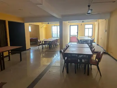 a dining room with tables and chairs and windows at Aishvarya Residency in Coimbatore