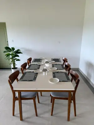 a long table with chairs and a large table with plates at Leopard Hill Resort - Bandipur in Bandipūr