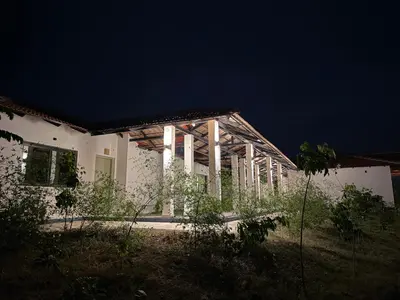 a white house with a dark sky behind it at Leopard Hill Resort - Bandipur in Bandipūr