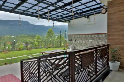 a balcony with a table and a view of a garden at Banbury Bungalow in Kanthalloor