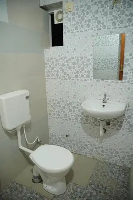 a bathroom with a toilet and a sink at Dormer Stay in Kozhikode