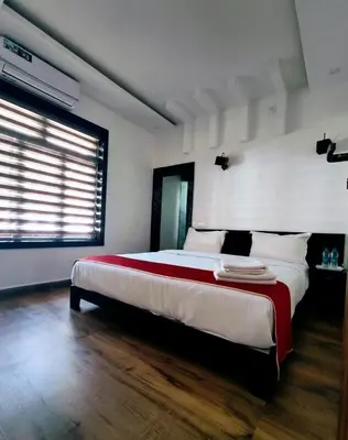 a bedroom with a large bed and a window at Forest Soul by BOB Hotels - Forest Retreat with Pool in Batheri