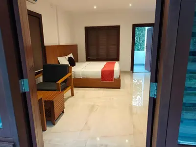 a bedroom with a bed and a chair and a window at Forest Soul by BOB Hotels - Forest Retreat with Pool in Batheri