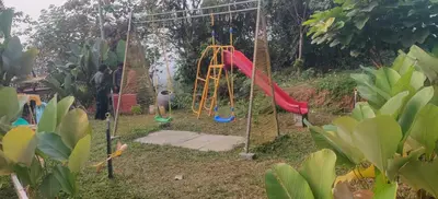 a playground with a slide in a garden at Jalsa Bali, Kakkadampoyil, Calicut in Kakkadampoyil