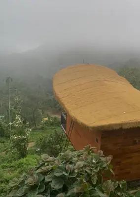 a hut with a straw roof on top of a hill at Jalsa Bali, Kakkadampoyil, Calicut in Kakkadampoyil