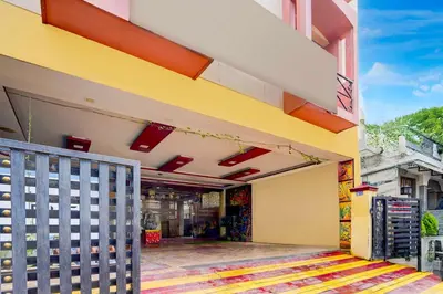 a store front with a yellow and orange building at Hotel O Gandhipuram Central Bus Stand in Coimbatore