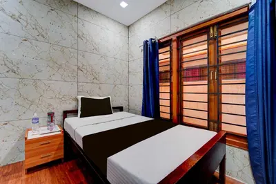 a small bedroom with a bed and a window at Hotel O Gandhipuram Central Bus Stand in Coimbatore
