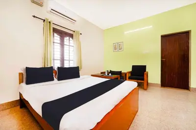 a bedroom with a large bed and two chairs at Collection O Singanallur Coimbatore in Coimbatore