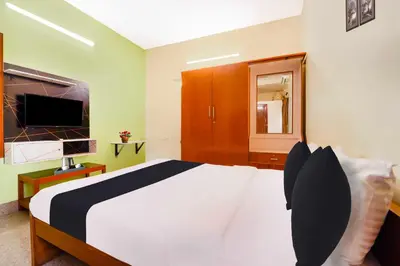 a bedroom with a white bed and a television at Collection O Singanallur Coimbatore in Coimbatore