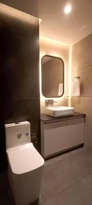 a bathroom with a white toilet and a sink at The Palazzo Chakolas in Trichūr
