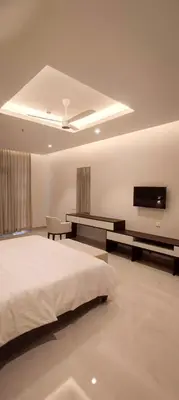 a bedroom with a bed and a flat screen tv at The Palazzo Chakolas in Trichūr