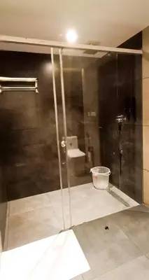 a glass shower in a bathroom with a sink at The Palazzo Chakolas in Trichūr