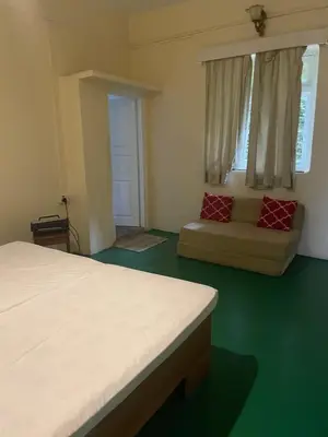 a bedroom with a bed and a couch in it at Glenwood in Coonoor