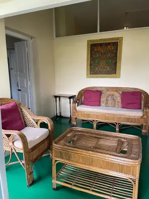 two wicker chairs and a bed in a room at Glenwood in Coonoor