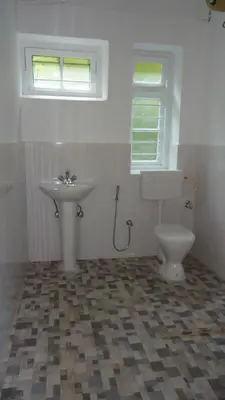 a bathroom with a toilet and a sink at Glenwood in Coonoor