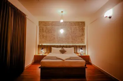 a bedroom with a bed and two night stands with lamps at Whitelake Resort in Bilikere