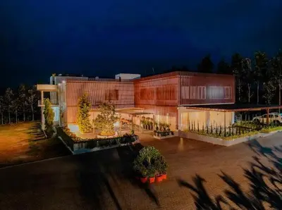 a large building is lit up at night at Whitelake Resort in Bilikere