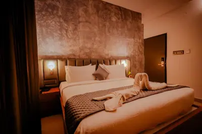 a bedroom with a large bed with white sheets at Whitelake Resort in Bilikere