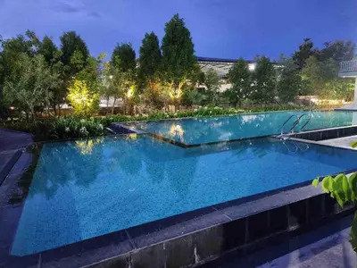 a swimming pool in a backyard at night at Whitelake Resort in Bilikere