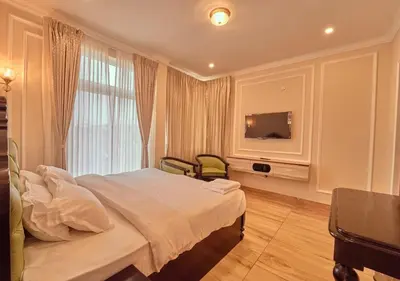 a hotel room with a bed and a television at King Palace Ooty by VOYE HOMES in Ooty