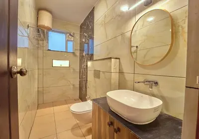 a bathroom with a sink and a toilet and a mirror at King Palace Ooty by VOYE HOMES in Ooty