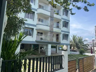 a building with balconies and a fence at Enhance Lifestyle Service Apartments in Thamarassery