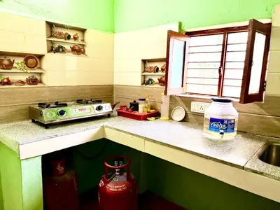 a kitchen with a stove and a sink and a counter at GSC Family Cottage in Samattūr