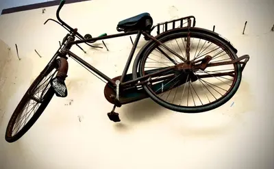 an old bike is hanging on a wall at GSC Family Cottage in Samattūr