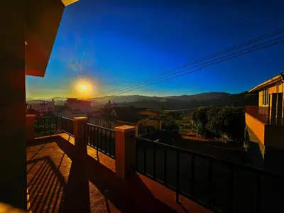 a view of the sunset from the balcony of a house at Sait's Westhill View Resort in Ooty