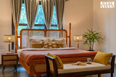 a bedroom with a large bed and a window at Stayvista at Serenova with big pvt pool and lawn - Your Luxury escape awaits ! in Madikeri