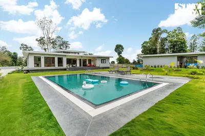 a house with a swimming pool in a yard at Stayvista at Serenova with big pvt pool and lawn - Your Luxury escape awaits ! in Madikeri