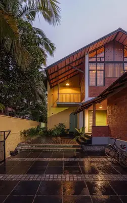 a house with a courtyard in front of it at Tranquil Nest in Kozhikode