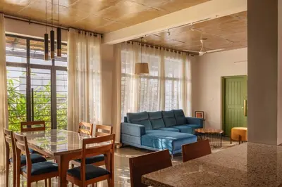 a living room with a blue couch and a table at Tranquil Nest in Kozhikode