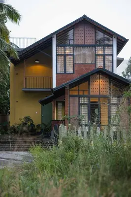a house with a large window on the side of it at Tranquil Nest in Kozhikode