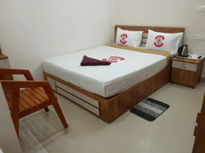 a small bedroom with a bed and a chair at Benzy Tourist Home in Ponnāni