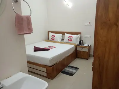 a small bedroom with a bed and a sink at Benzy Tourist Home in Ponnāni
