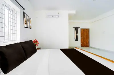 a white room with a black and white bed at Hotel O Coimbatore Brookefields Mall in Coimbatore