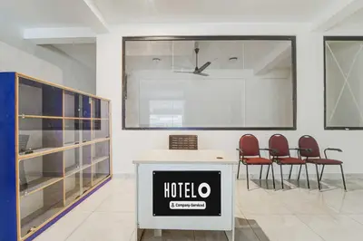 a hotel room with red chairs and a large window at Hotel O Coimbatore Brookefields Mall in Coimbatore