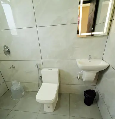 a bathroom with a toilet and a sink at Revoura Heights Apartments in Sultan Bathery