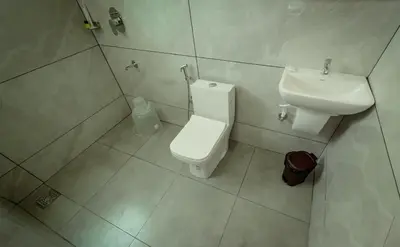 a bathroom with a toilet and a sink at Revoura Heights Apartments in Sultan Bathery