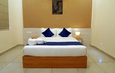 a bedroom with a large bed with blue and white pillows at Revoura Heights Apartments in Sultan Bathery