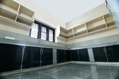 a large empty room with black cabinets and a window at Tranquil Rest House in Trichūr