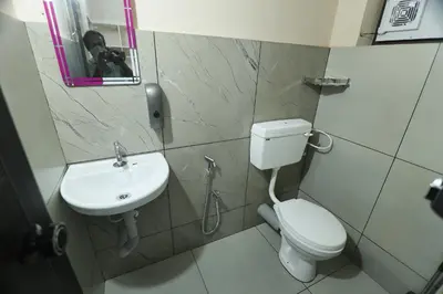 a bathroom with a toilet and a sink and a mirror at Tranquil Rest House in Trichūr