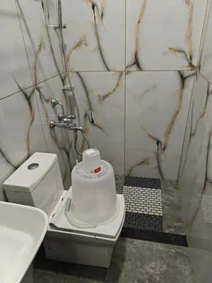 a white bathroom with a toilet and a sink at The Ooty Suites in Ooty