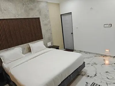 a bedroom with a large white bed with marble floors at The Ooty Suites in Ooty