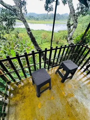 a pair of benches sitting next to a fence at Greenery Holiday Homes in Meppādi